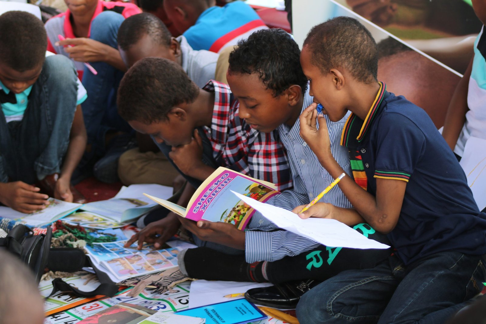 boy in blue and white plaid shirt reading book