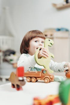 Girl in White Long Sleeve Top Playing With Toys